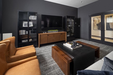 A living room with a brown leather chair and a black coffee table.