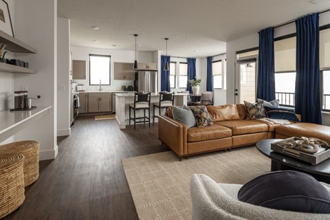 A living room with a brown couch and a grey armchair.