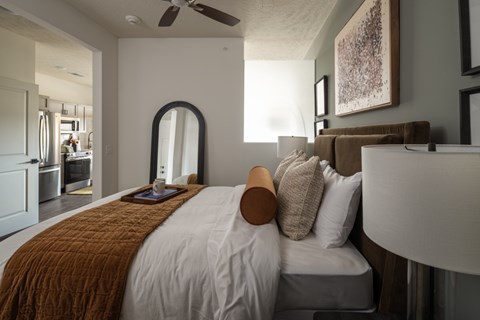 A bedroom with a large bed and a mirror on the wall.
