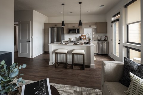 A modern kitchen with a dining area and a living room.