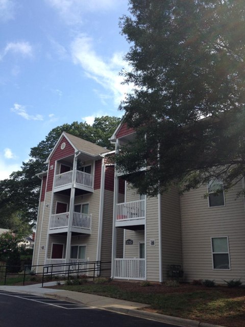 Apartment building with a red roof and white balconies.