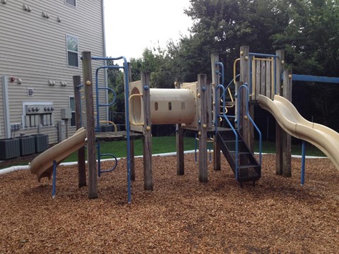 A playground with a slide, swings, and a tunnel.