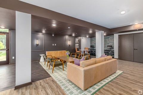 A living room with a couch, chairs, and a rug.