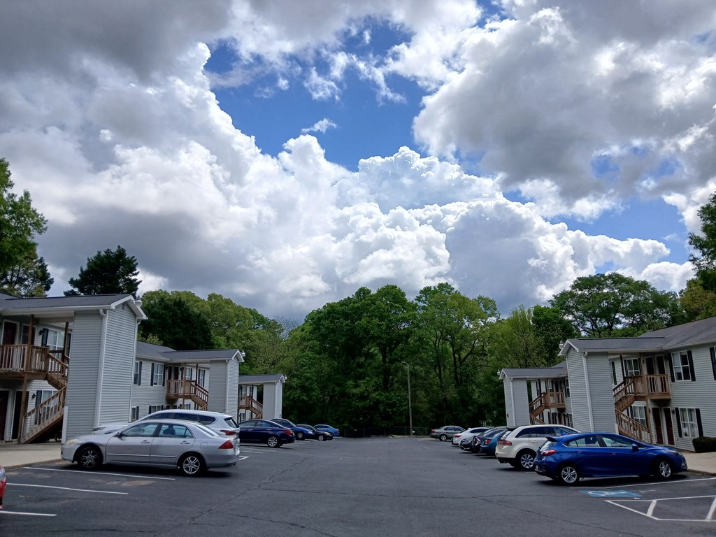 A parking lot with cars and apartment buildings in the background.