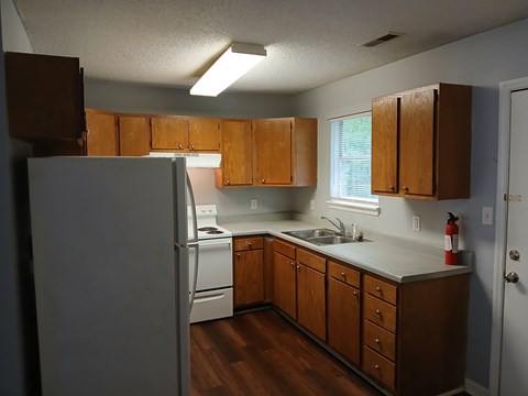 A kitchen with wooden cabinets and a white refrigerator.