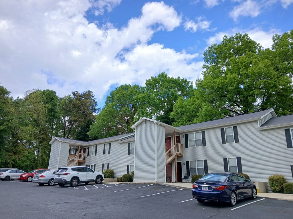 A car is parked in a parking lot in front of a building.