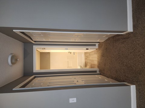 A modern, empty kitchen with a large island in the middle.