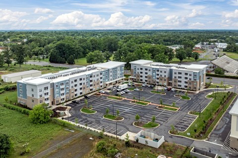 A large building complex with a parking lot in front.