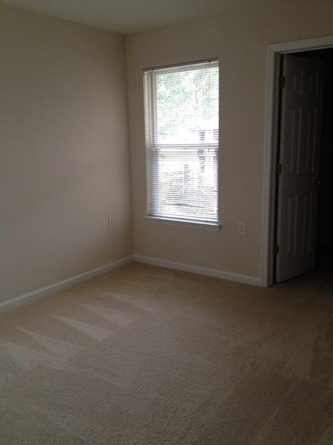 an empty room with a window and a door