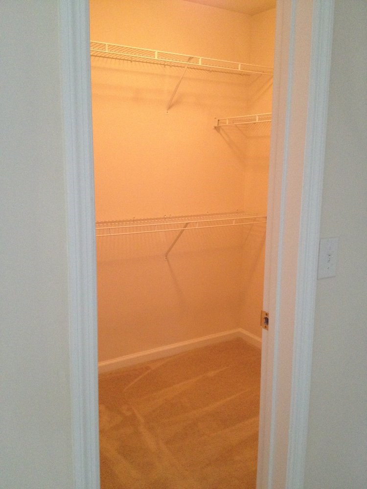 an empty closet in a bathroom with a white door
