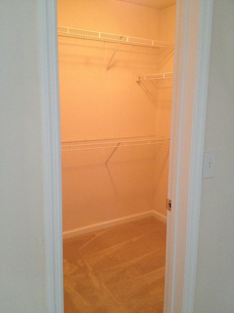 an empty closet in a bathroom with a white door