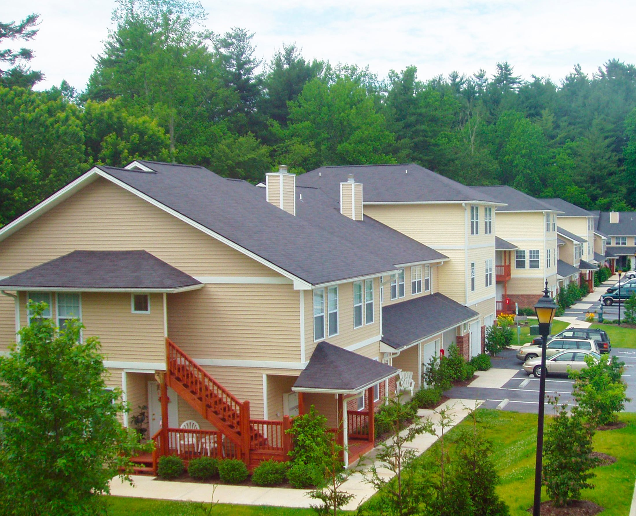 A row of houses with a tree in the background.