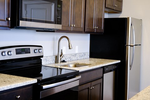 an updated kitchen with black appliances and granite counter tops