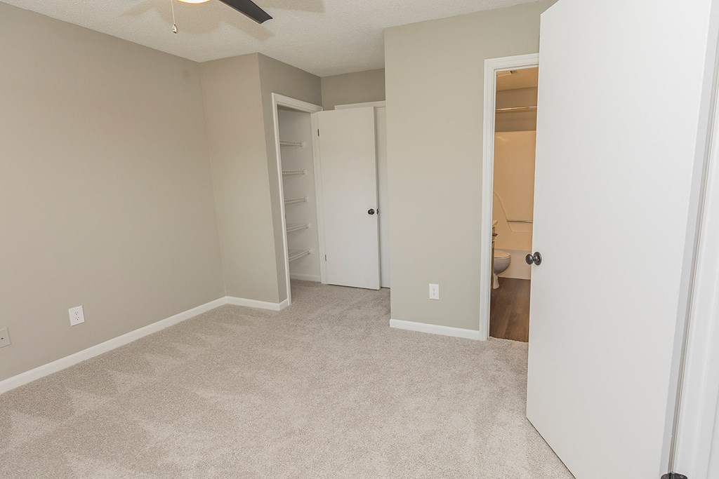an empty bedroom with a closet and a bathroom