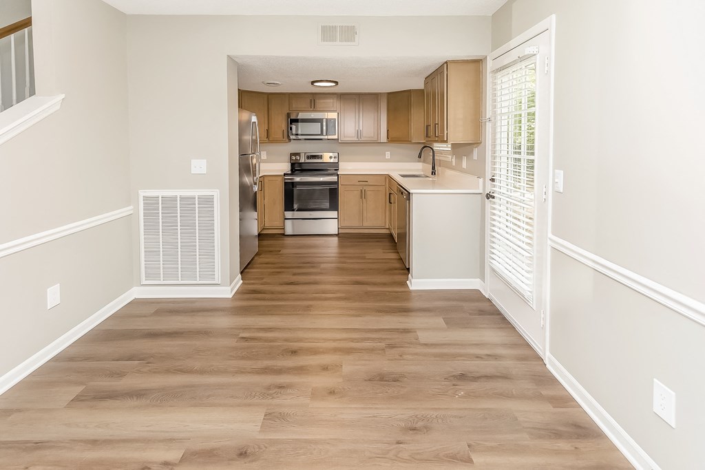 an empty kitchen with wooden floors and wooden cabinets