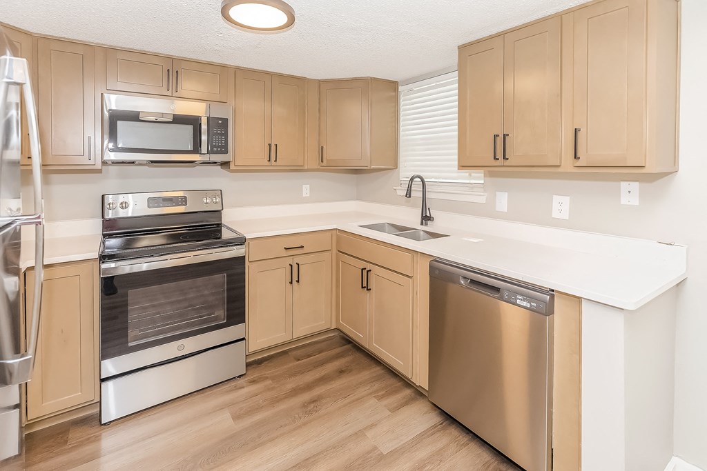 a kitchen with wooden cabinets and stainless steel appliances