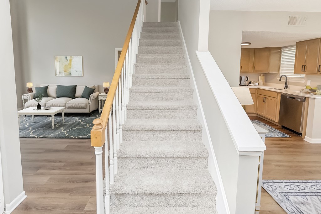 a staircase in a home with a living room and a kitchen