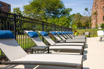 a row of lounge chairs in front of a fence