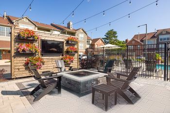 outdoor lounge with seating around a fire pit and TV
