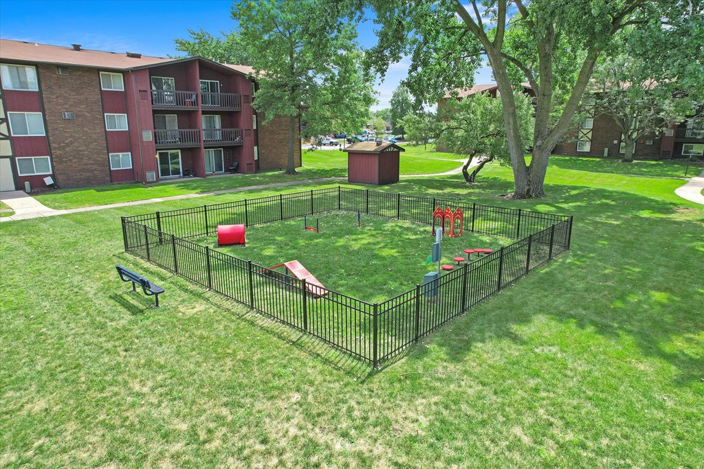a fenced in dog park in the middle of a yard