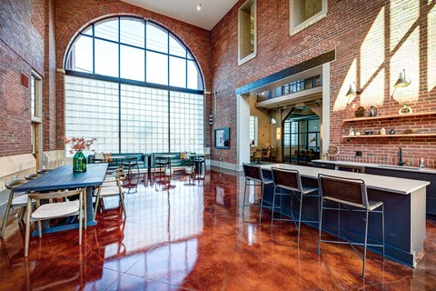 A kitchen with a table and chairs in front of a large window.
