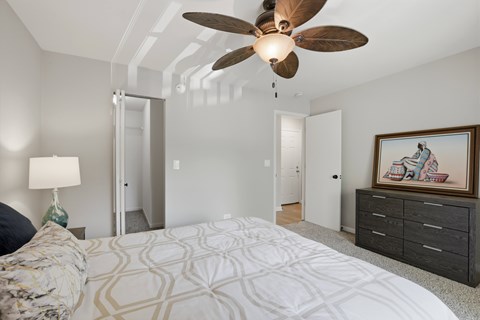 A bedroom with a large bed and a ceiling fan.