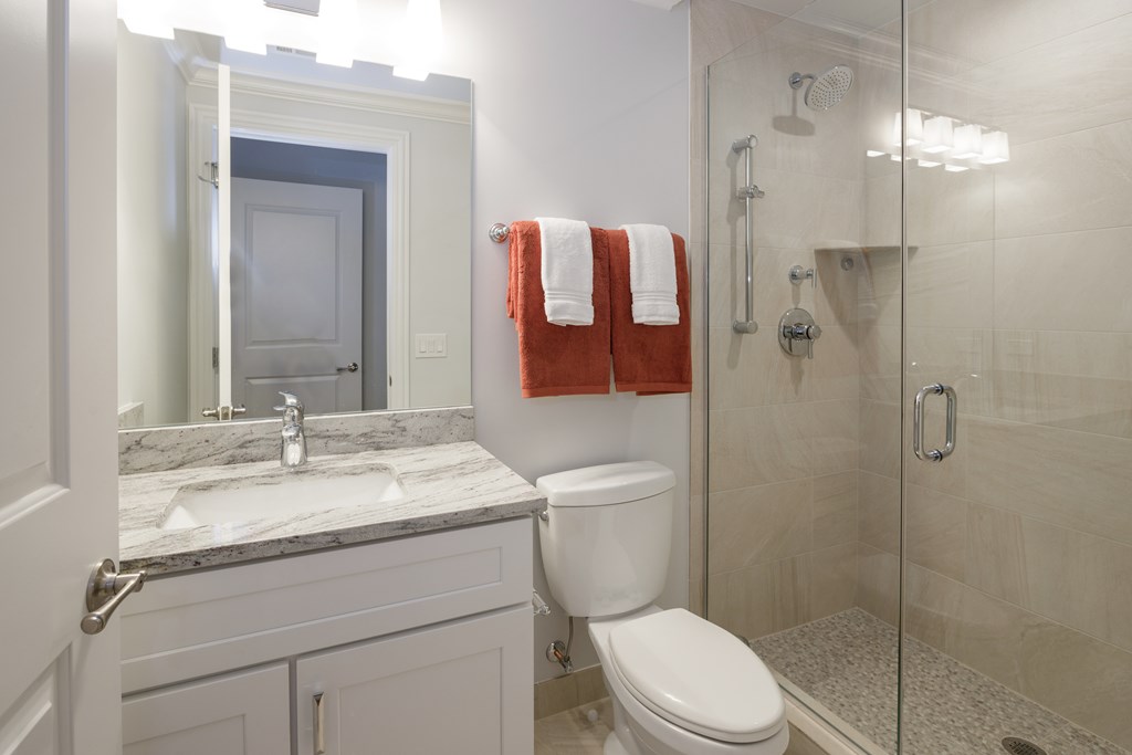 A bathroom with a toilet, sink, and shower.