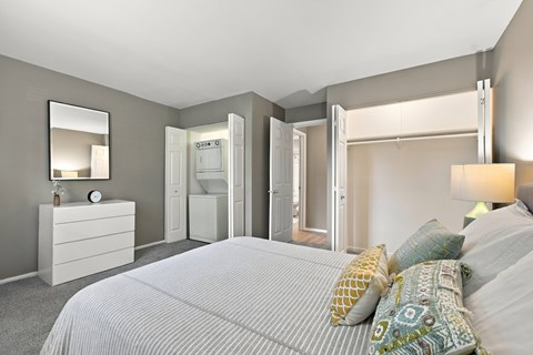 A bedroom with a large bed and a dresser with a mirror.