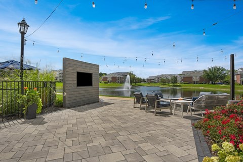 A patio area with a table and chairs and a fountain.