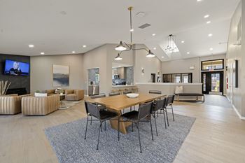 A modern living room with a wooden dining table and chairs.