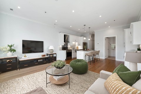 A modern living room with a glass coffee table and a green bean bag chair.