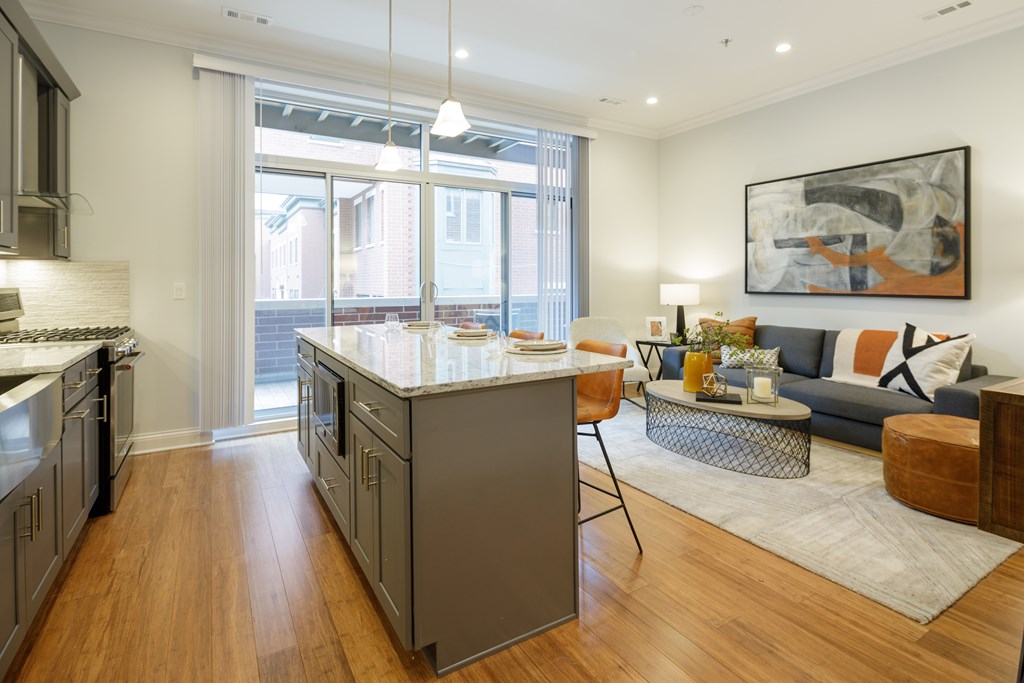A modern kitchen with a large island and a view of the backyard.