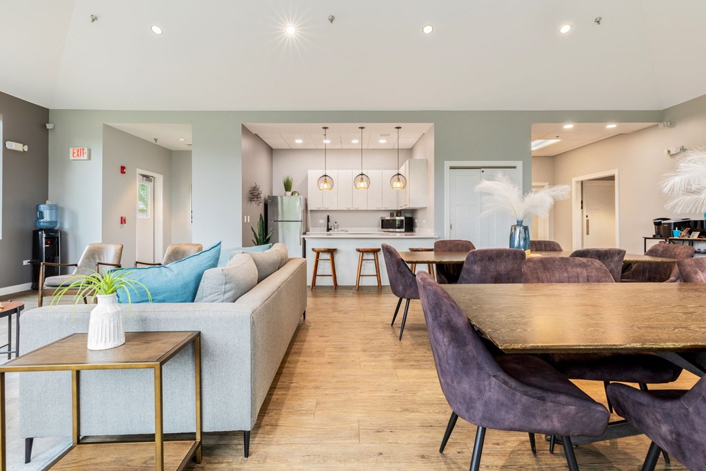 a living and dining room area with a kitchen in the background and a kitchen island in the