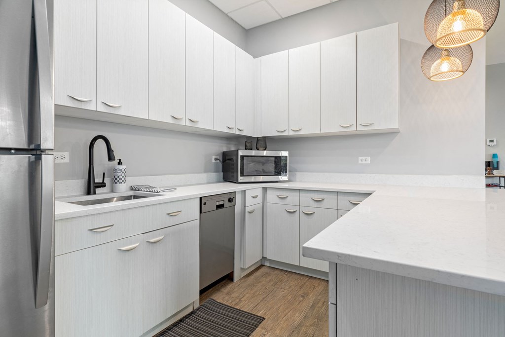 a kitchen with white cabinets and a stainless steel dishwasher