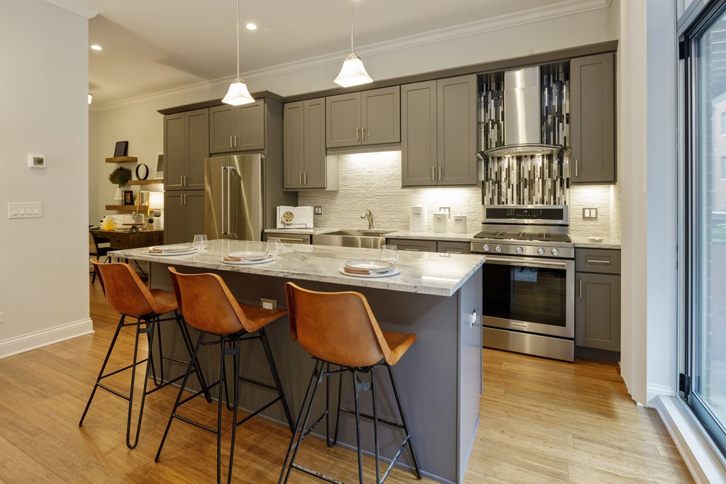 A modern kitchen with a large island and bar stools.