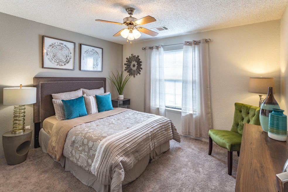 a bedroom with a large bed and a ceiling fan