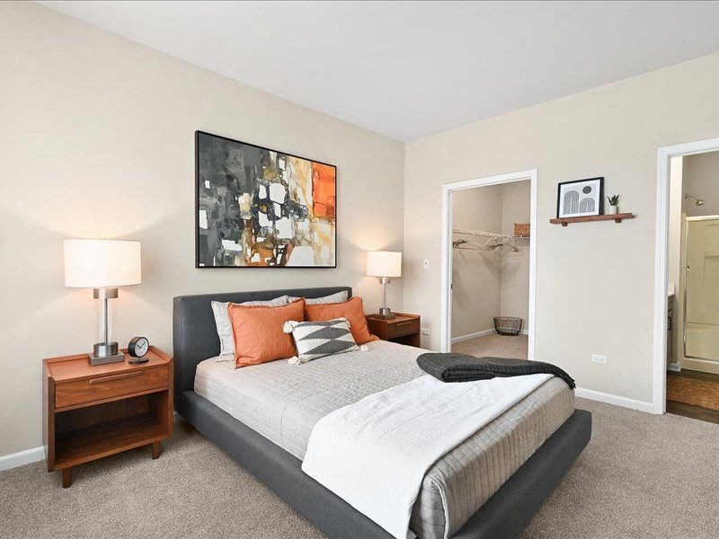 furnished bedroom with a large walk-in closet and attached bathroom