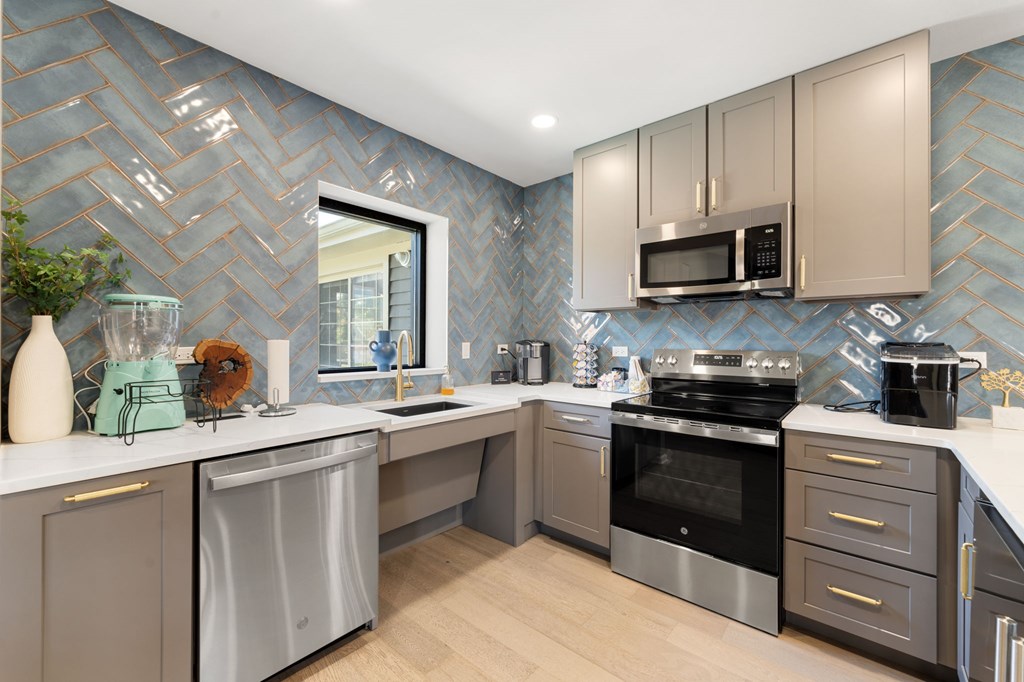 A modern kitchen with a stove top oven and a dishwasher.