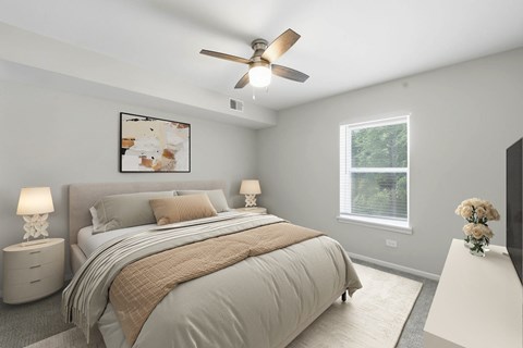 A bedroom with a large bed and a ceiling fan.