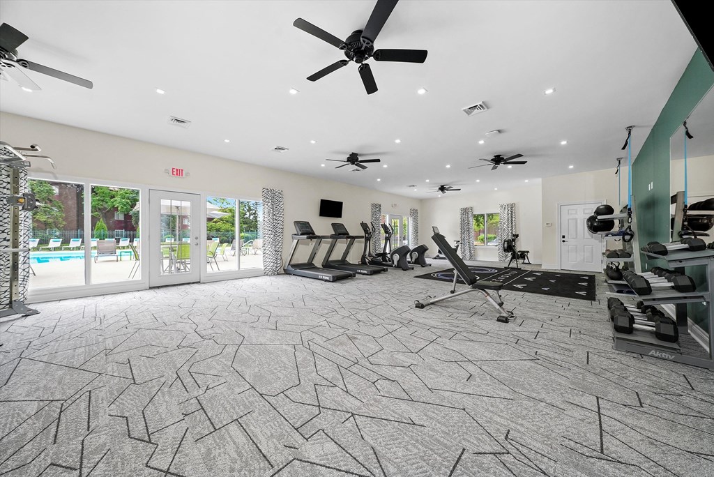 a gym with chairs and a ceiling fan