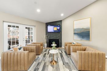 A living room with a fireplace, a television, and a painting on the wall.