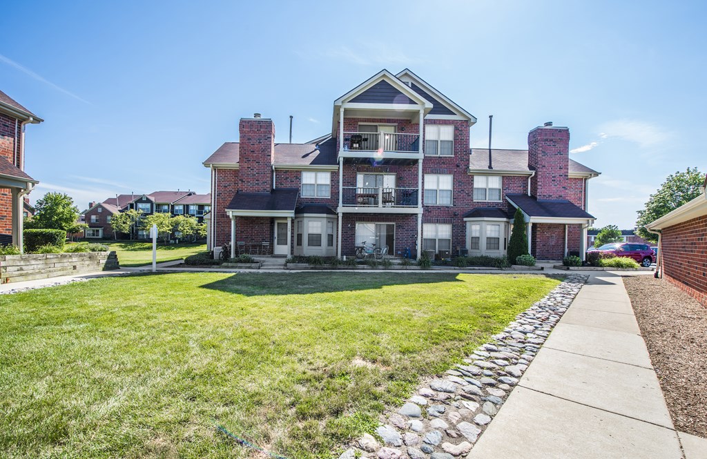 a house with a yard and a sidewalk in front of it