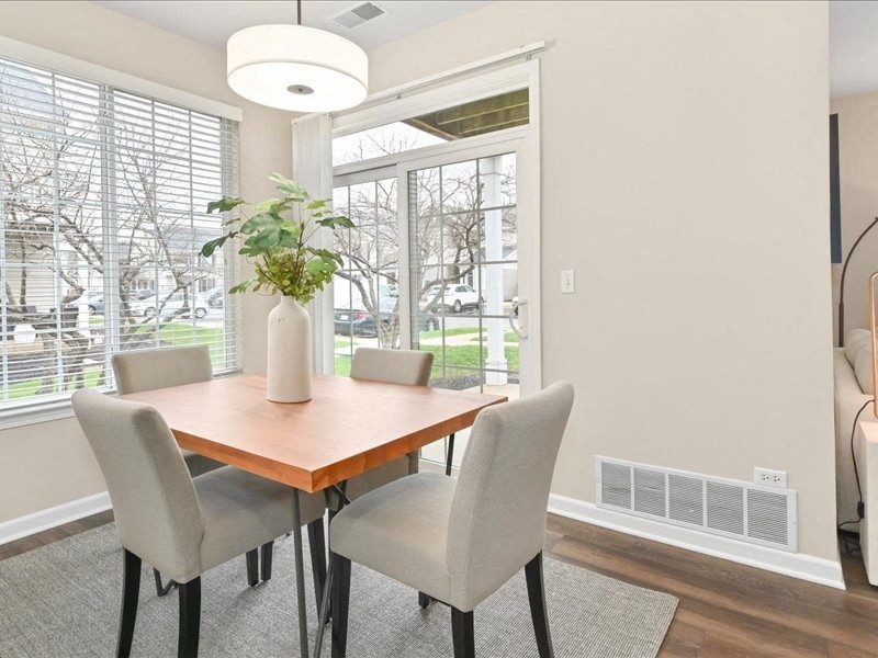 dining table with four chairs situated in a corner near the back sliding glass door of a Farmington Lakes home