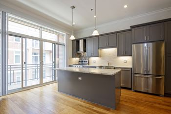 A modern kitchen with a large island and stainless steel appliances.