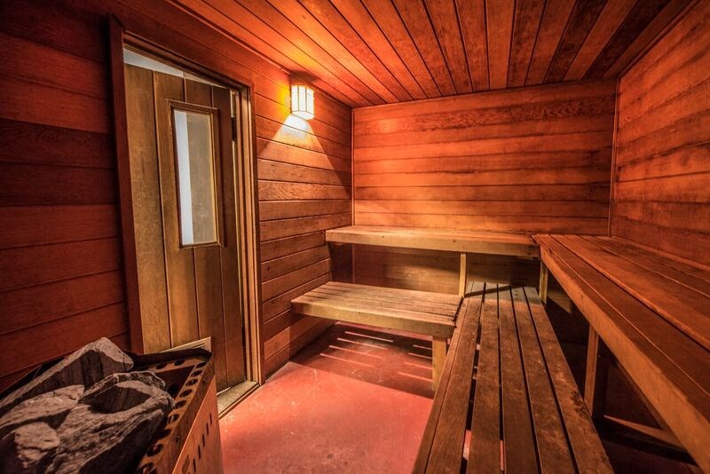 a wooden sauna with a bench and a table