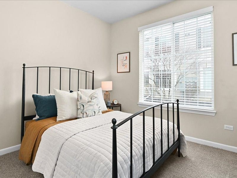 bedroom with a wrought iron bedframe and large window