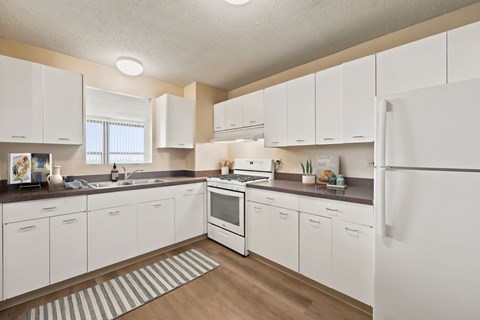 A kitchen with white cabinets and appliances.