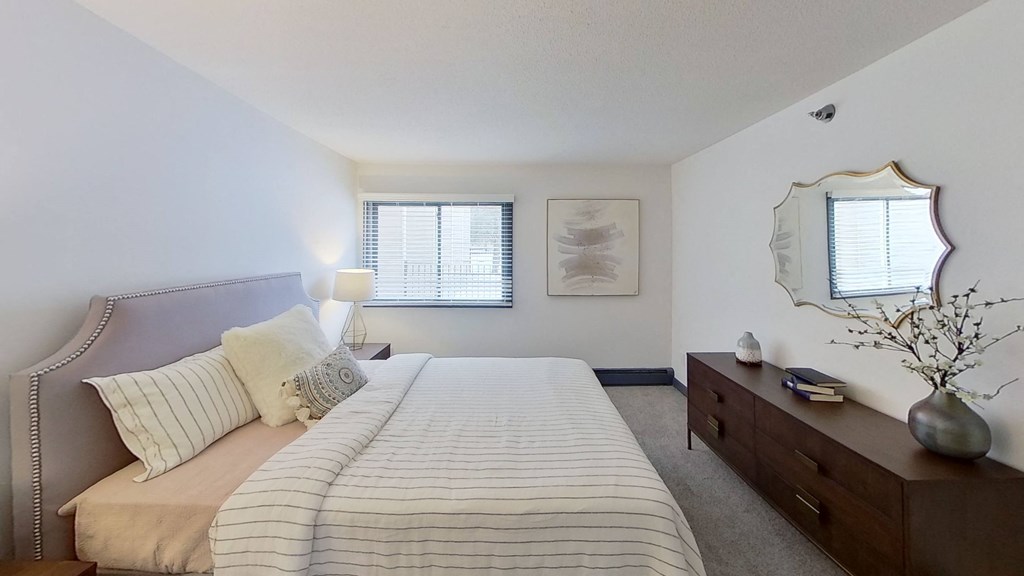 a bedroom with a bed and a dresser and a window