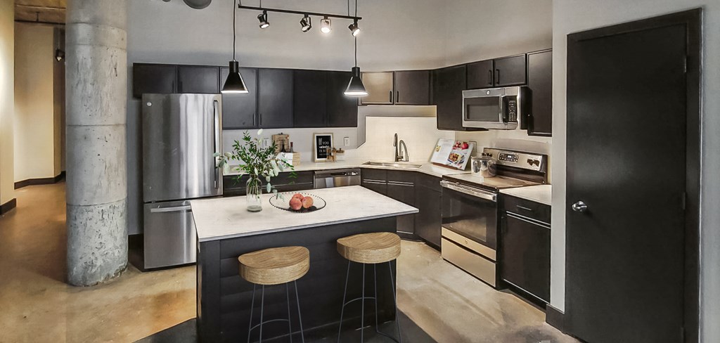 a kitchen with black cabinets and a white counter top