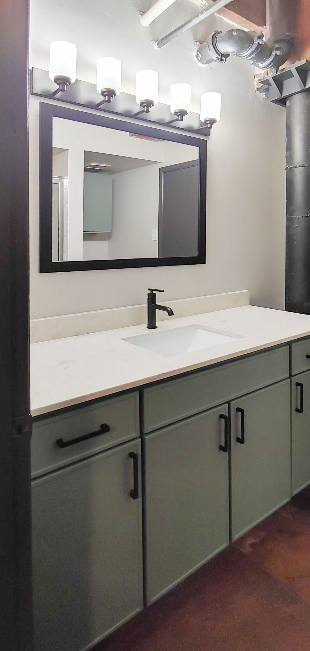 sage vanity with a white quartz countertop